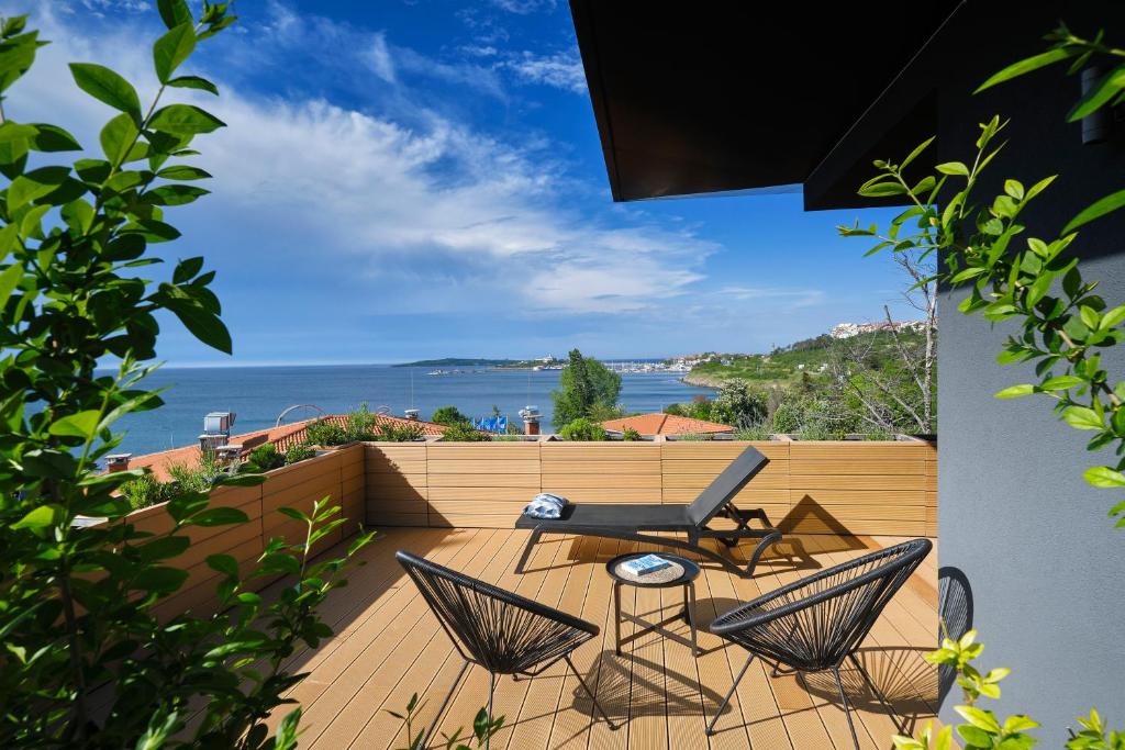 balcón con mesa, sillas y vistas al océano en Viva Mare Beach Hotel by Santa Marina, en Sozopol