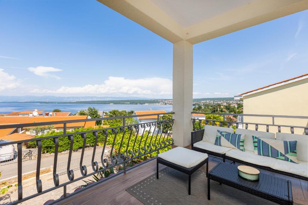 a balcony with a couch and a view of the water at Apartment Daisy in Vantačići