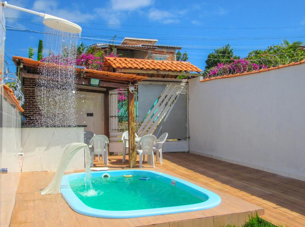 a swimming pool with a water fountain on a patio at Casa com Piscina e Churrasqueira em Vera Cruz BA in Barra Grande