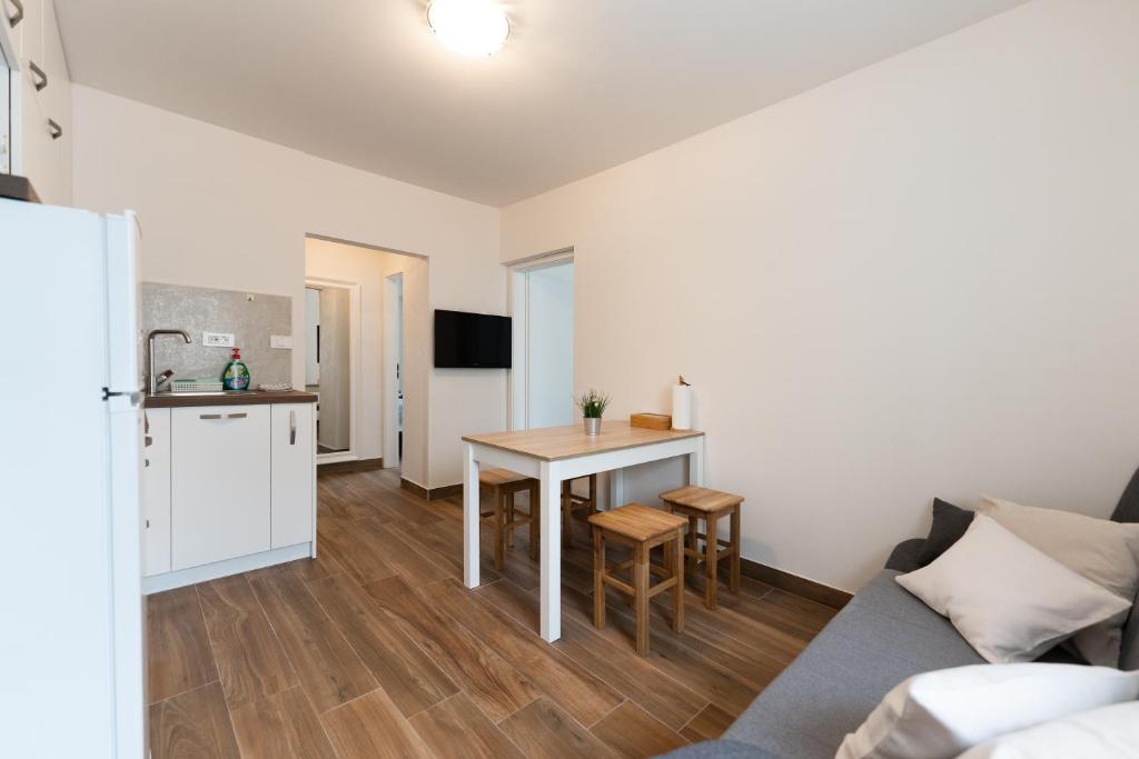 ein kleines Wohnzimmer mit einem Tisch und einer Küche in der Unterkunft Tramontana and Maestral in Izola