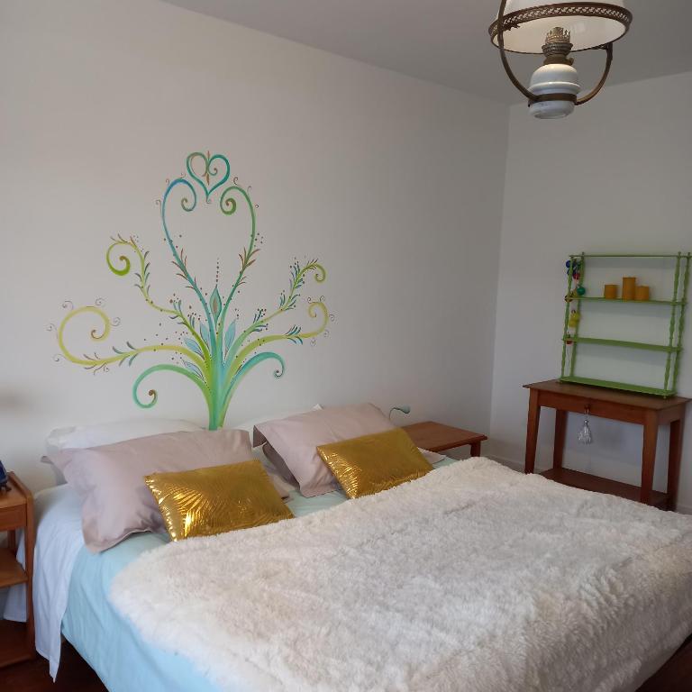 a bedroom with a bed with two pillows on it at Chambres d'Hôtes Couleurs d'Elvine in Coutances