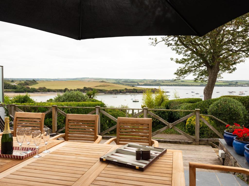 a wooden table with chairs and an umbrella at Little Strand in Padstow