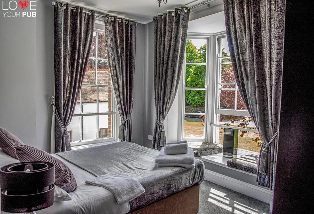 una camera con un letto e una grande finestra di The Robin Hood Inn a Rowlands Castle