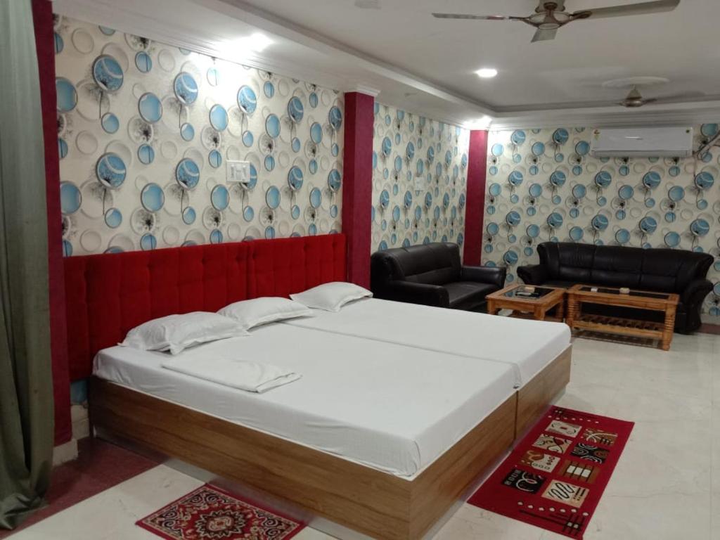 a bedroom with a large bed and a living room at Hotel Geetanjali Buddha Resort By WB Inn in Bodh Gaya