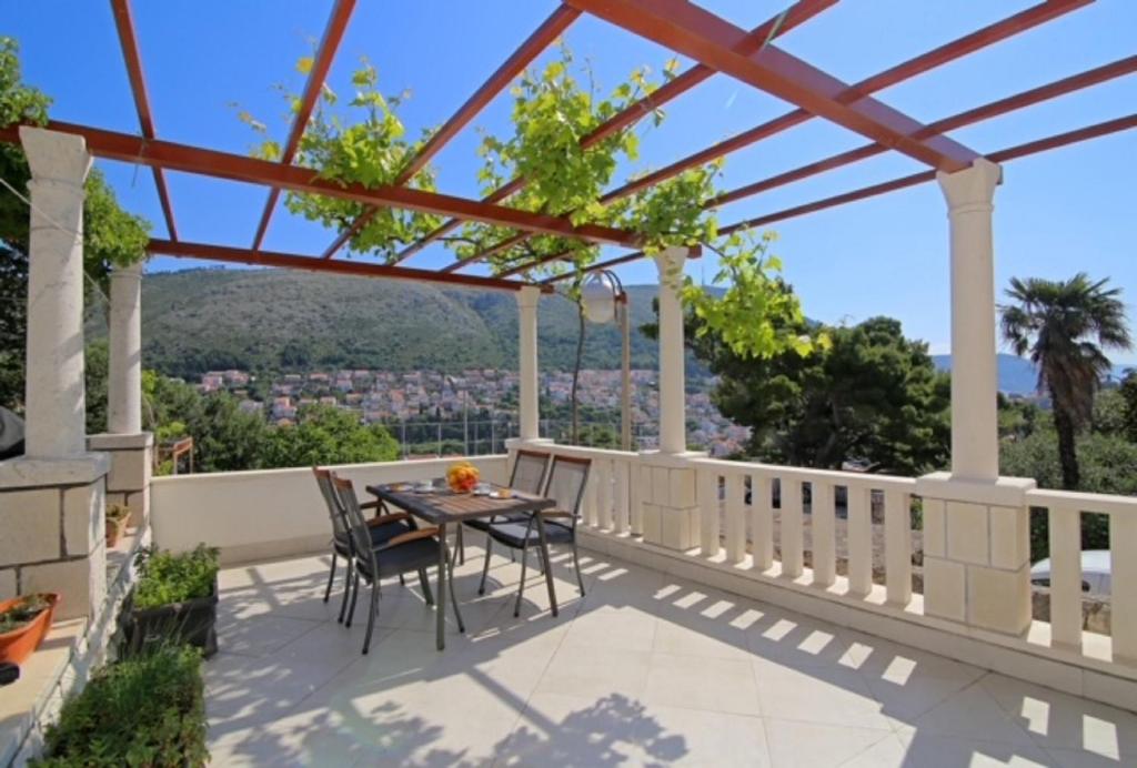 patio ze stołem i krzesłami na balkonie w obiekcie Dubrovnik Hill Apartments w Dubrowniku