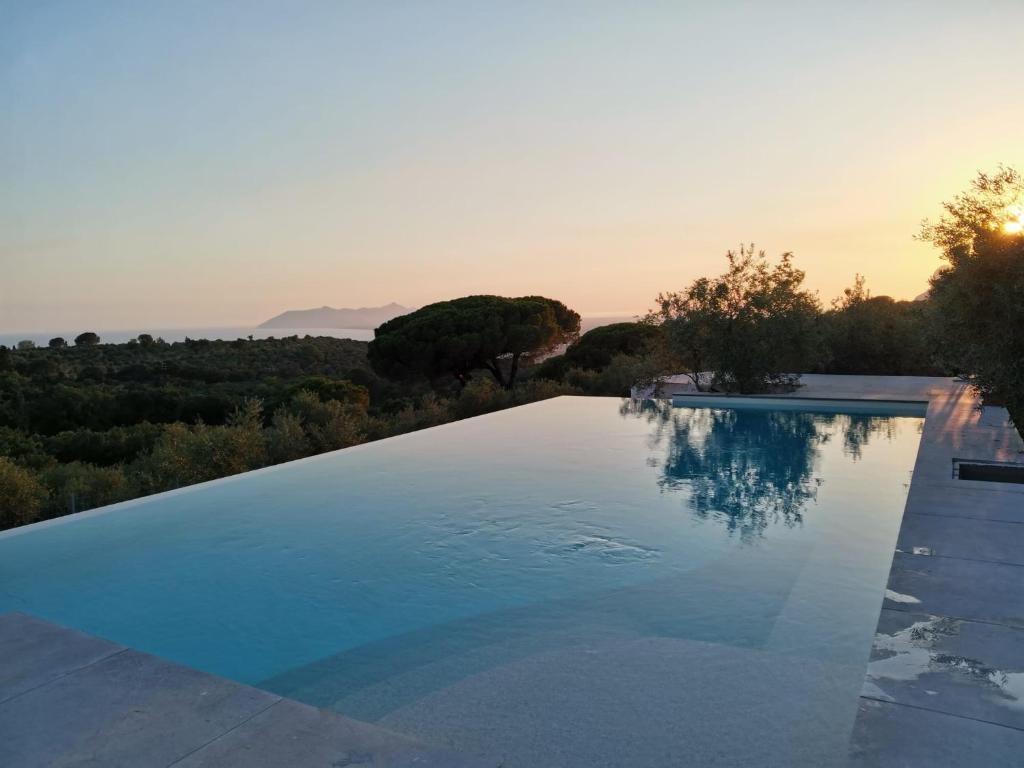 a swimming pool with a sunset in the background at Villa Letizia in Terracina