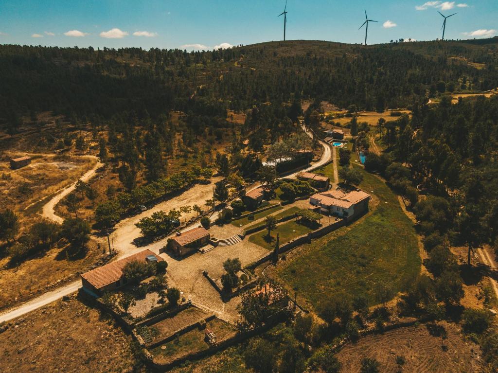 une vue aérienne sur une ferme avec des éoliennes sur une colline dans l'établissement Moinho d'Antoninha, à Leomil