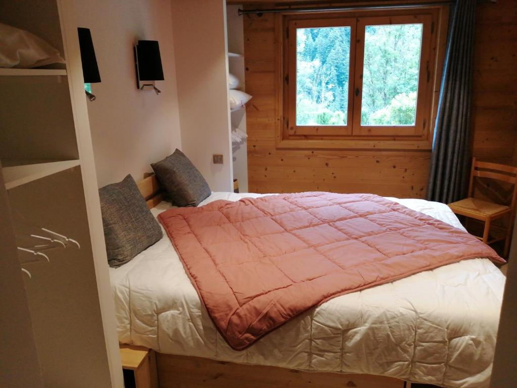 sypialnia z łóżkiem i oknem w obiekcie Chalet Cathy et Michel w mieście Seytroux