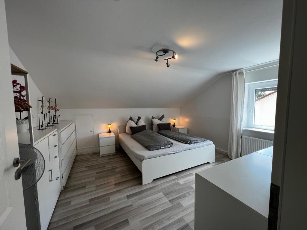 a white bedroom with a bed and a window at Ferienwohnung Schlüter Nußloch in Nußloch