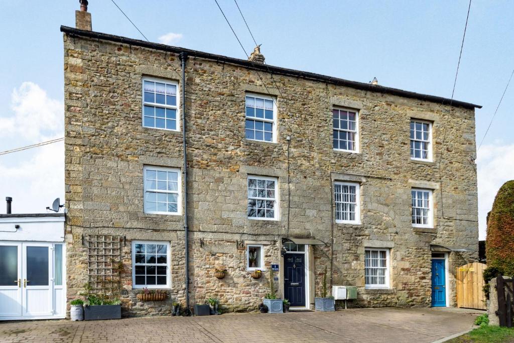 an old stone house with white doors and windows at Field View Apartment in Barnard Castle