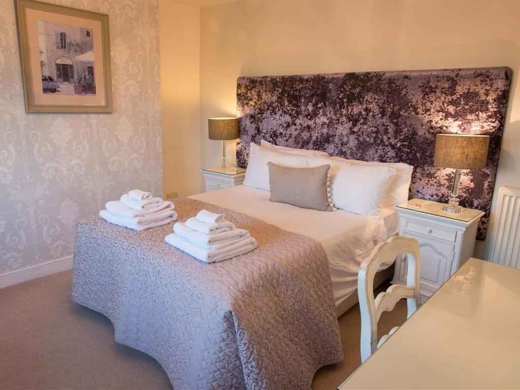 a bedroom with a bed with towels on a table at The Blackamoor Inn in Ripon