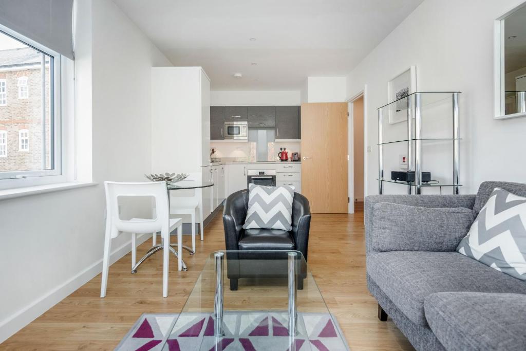 ein Wohnzimmer mit einem Sofa und einem Tisch in der Unterkunft Roomspace Serviced Apartments - Swan House in Leatherhead