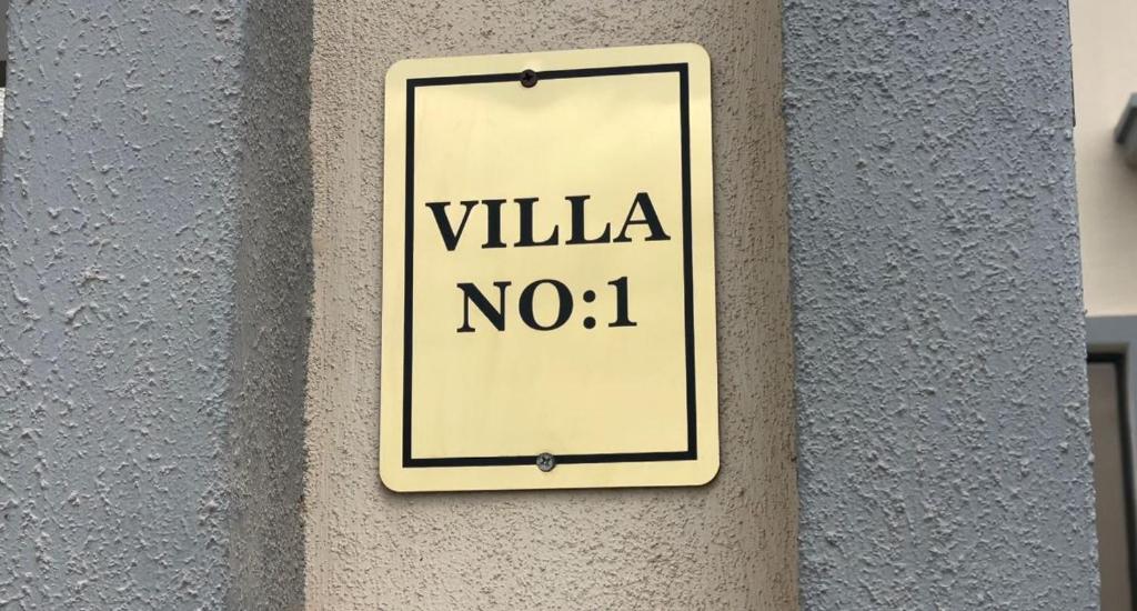 a sign on a wall that reads villa no at Al Jabal Resort villa 1 in Salalah