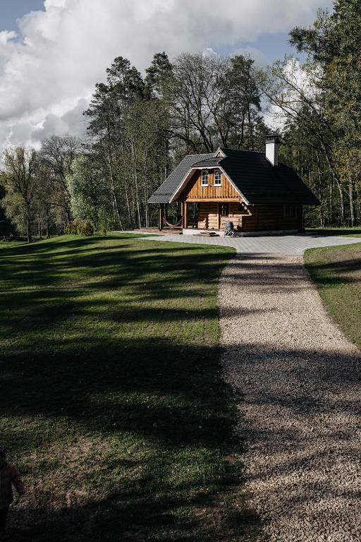 a log cabin with a path leading to it at "Gaujmale" sauna house in nature in Laukbeitini