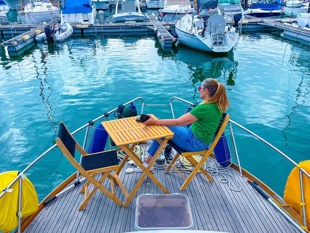 una mujer sentada en una mesa en la parte trasera de un barco en Stay in a Yacht - Algarve en Albufeira