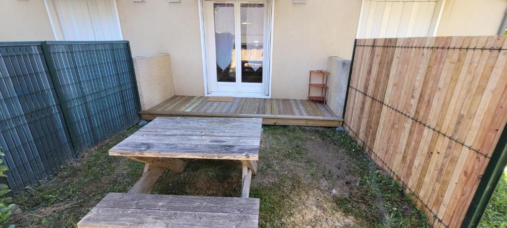un banc en bois assis devant une maison dans l'établissement Appartement de montagne, à Esquièze - Sère