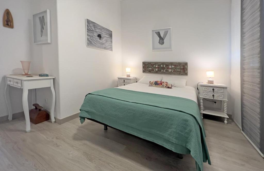 Schlafzimmer mit einem grünen und weißen Bett und einem Tisch in der Unterkunft Casa AL Reis in Faro