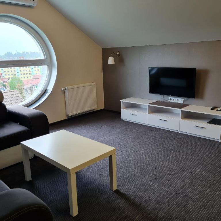 a living room with a tv and a coffee table at Apartament Wileńska in Mikołajki