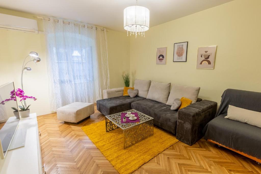 ein Wohnzimmer mit einem Sofa und einem Tisch in der Unterkunft Apartman Kortil in Rijeka