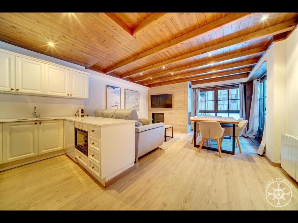 a kitchen and living room with a table and a kitchen and a dining room at ARGULLS de Alma de Nieve in Baqueira-Beret