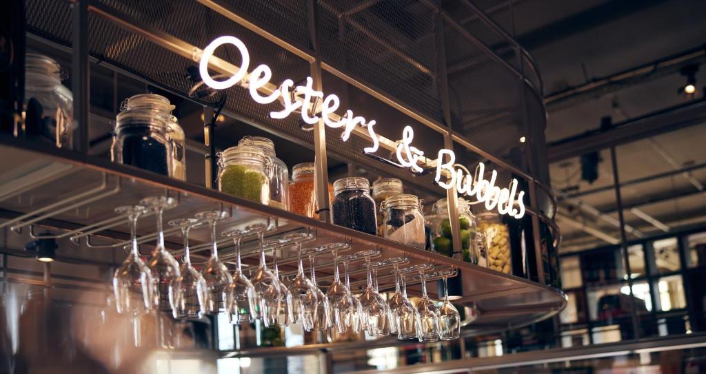 a bunch of wine glasses on a shelf in a bar at Hotel New York by WestCord in Rotterdam