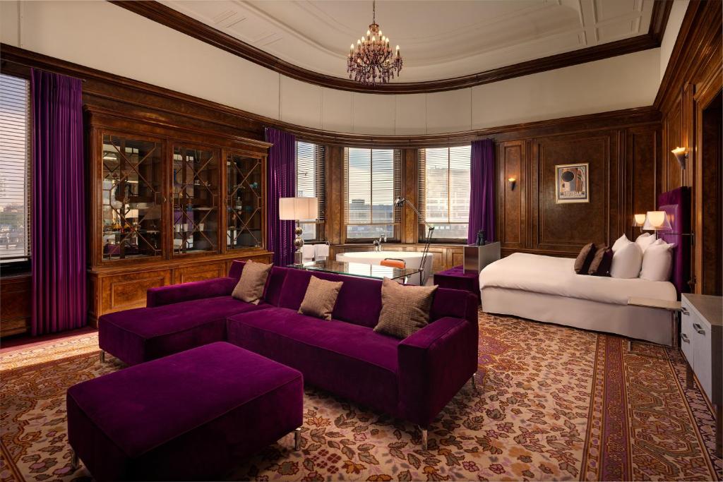 a living room with a purple couch and a bed at Hotel New York by WestCord in Rotterdam