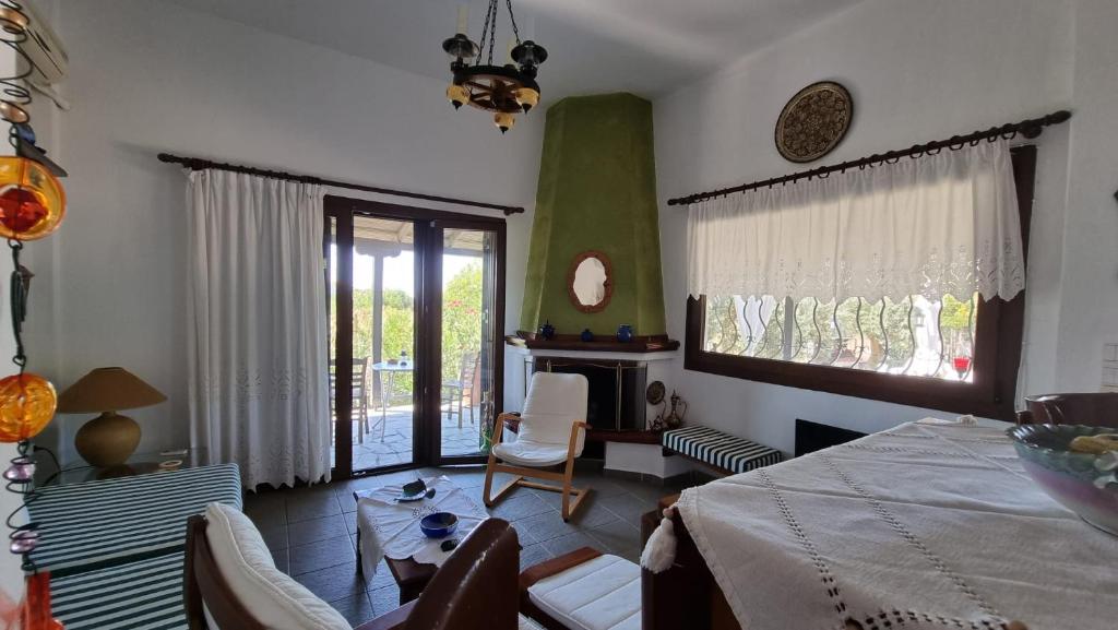 een woonkamer met een bed en een tafel en stoelen bij Sophia's cottage in Fourka