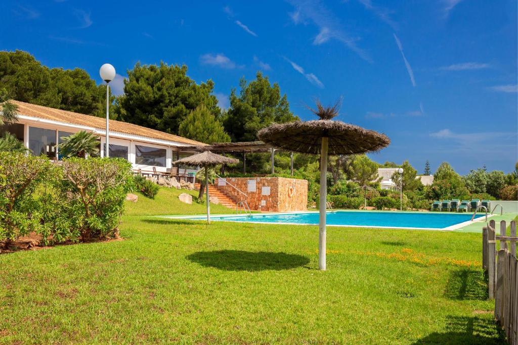 un patio con sombrilla y piscina en Apartamento Bellavista, en Punta Grossa