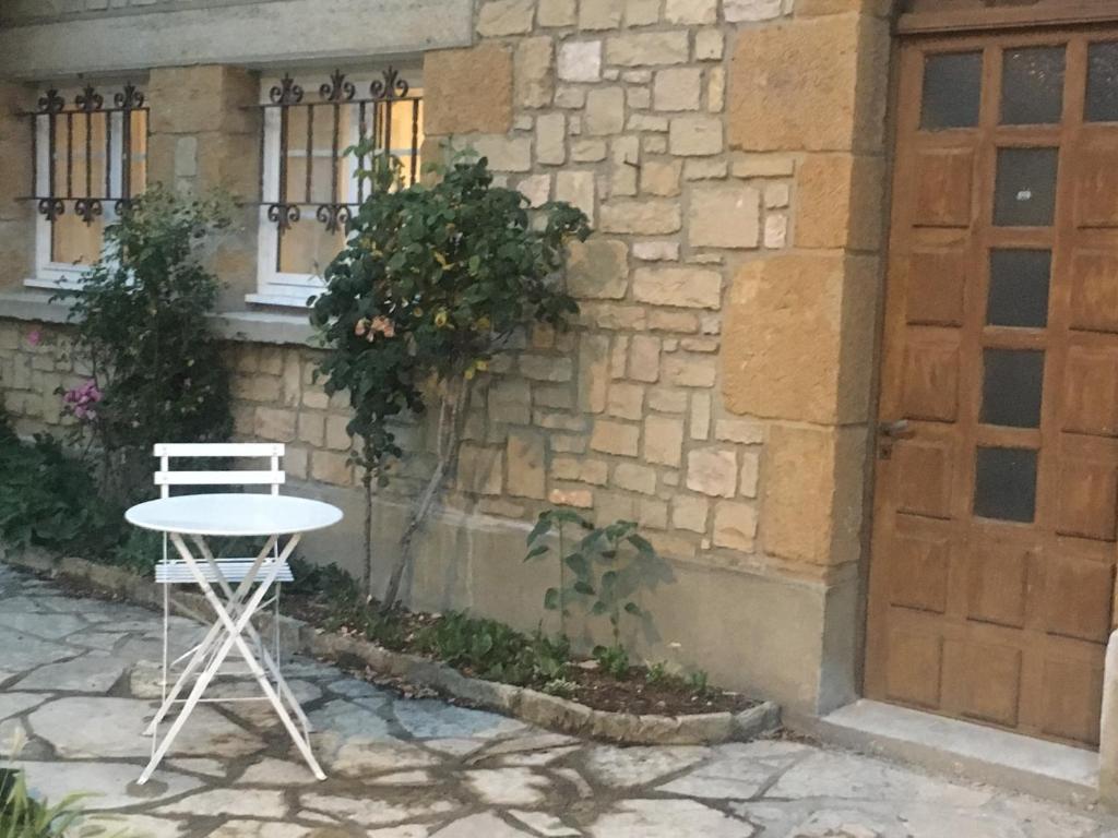 une chaise blanche et une table en face d'un bâtiment dans l'établissement Les studios de Philibert, à Figeac