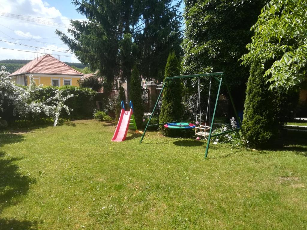 un patio con columpios en el césped en Evelin vendégház en Bogács