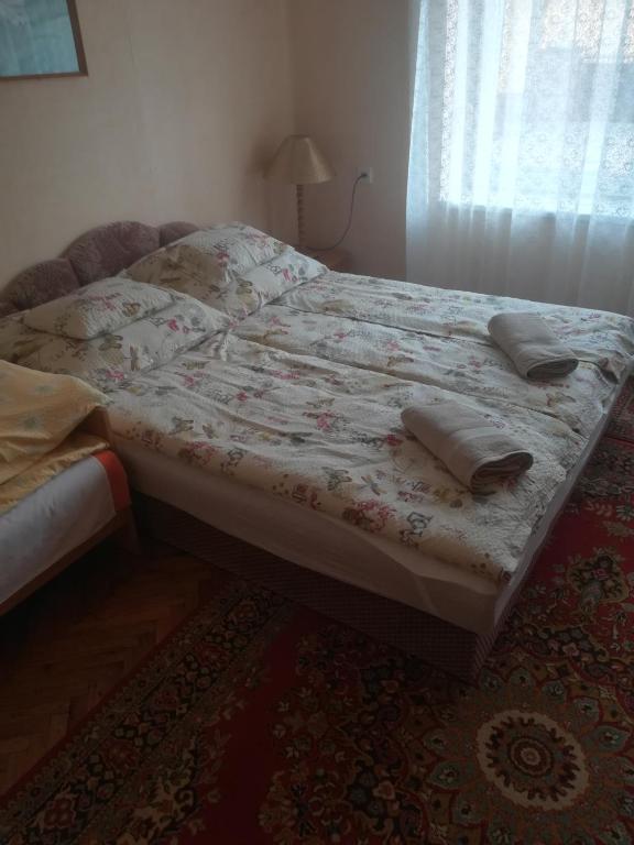 A bed or beds in a room at Evelin vendégház