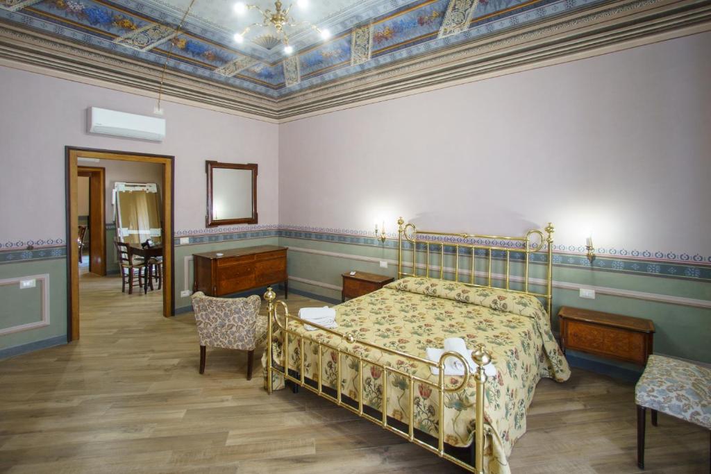 1 dormitorio con 1 cama, mesa y sillas en CEFAS Apartments, en Cefalú