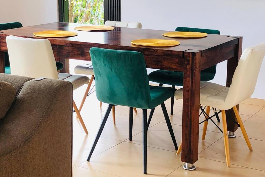 a dining room table with green chairs and a couch at Modern Luxury 3 bedroom house in Durban