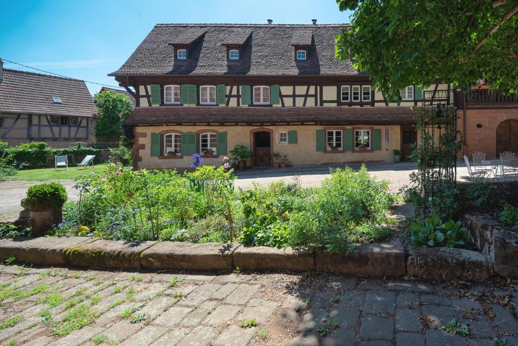 una vecchia casa con un giardino di fronte di Au Fil du Temps a Imbsheim