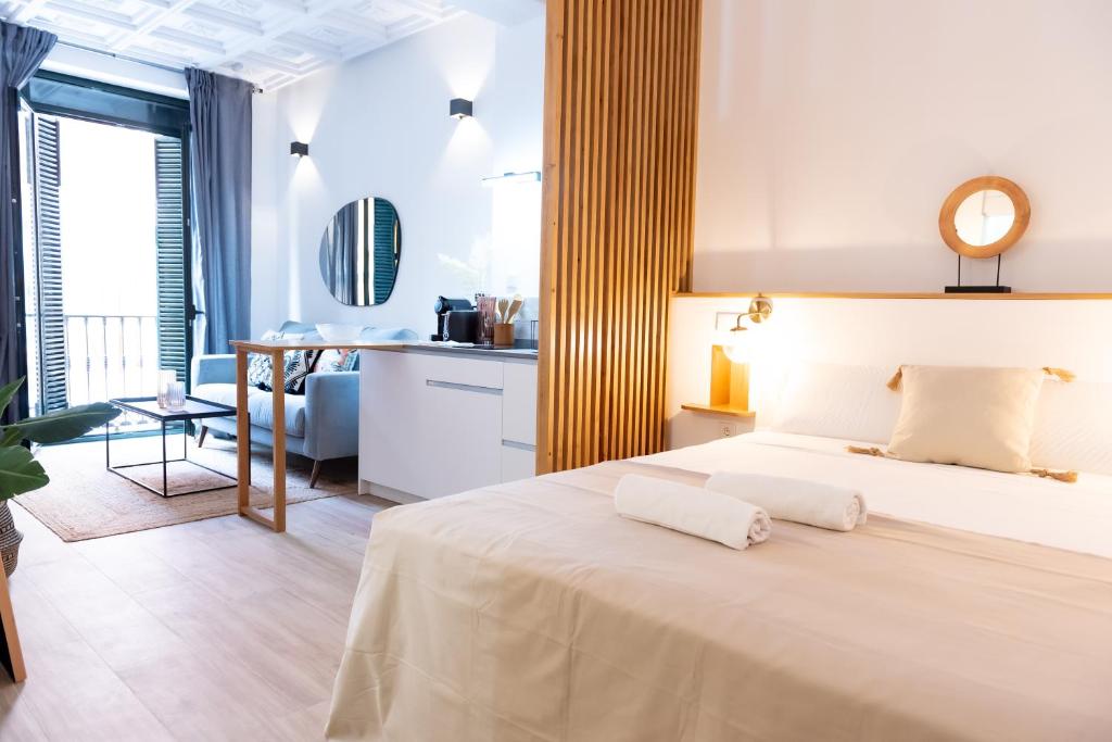 um quarto com uma cama branca e uma cozinha em Tourist House Alfalfa em Sevilha
