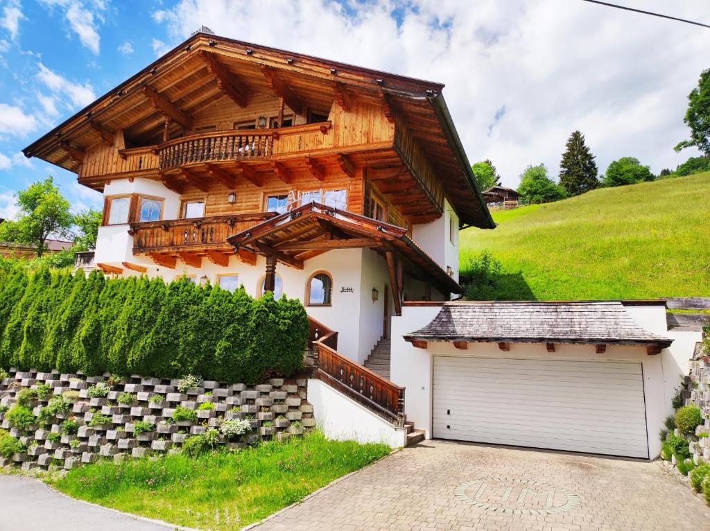 una casa de madera con un garaje delante de ella en Ferienwohnung Schatzberg Panorama WILD445 en Oberau