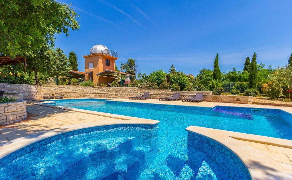 a swimming pool in front of a house with a observatory at Mit großem Pool, Gym, Tischtennis, Kicker, Observatorium, Volleyballplatz in Ližnjan