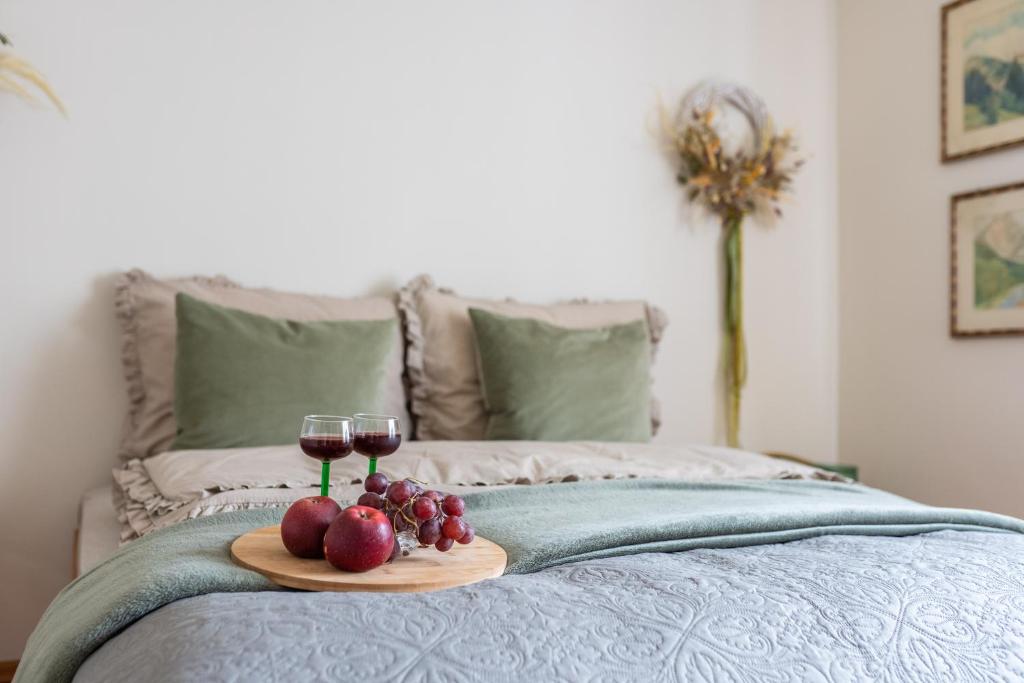 a tray with two glasses of wine and fruit on a bed at Ruciane Wianki DOM W SERCU WARMII in Purda