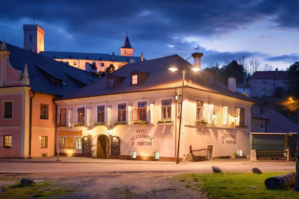 ein großes weißes Gebäude mit Lichtern in der Nacht in der Unterkunft Hotel U Martina in Rožmberk nad Vltavou