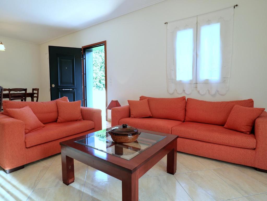 a living room with two red couches and a coffee table at Gloria's House in Kariá