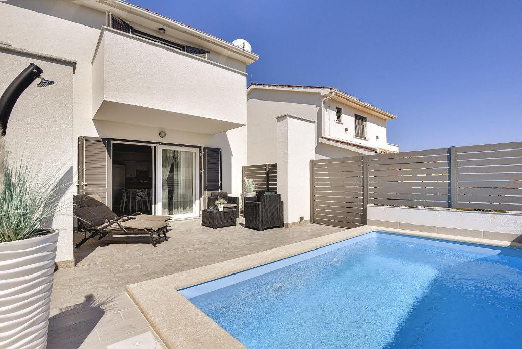 a swimming pool in the backyard of a house at 500 Meter zum Strand mit Privatpool, Meerblick, Klima, WLAN in Ližnjan