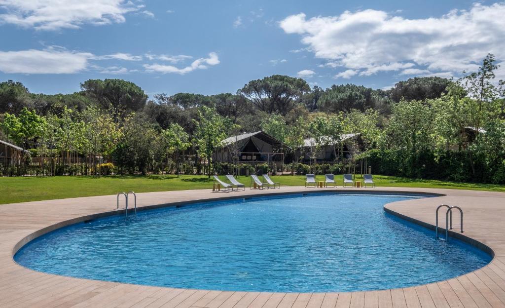 uma piscina com espreguiçadeiras num quintal em wecamp Santa Cristina em Santa Cristina d'Aro