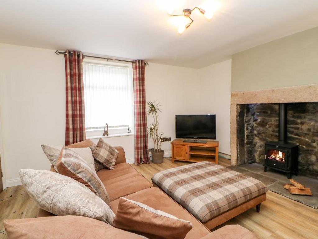 a living room with a couch and a fireplace at Bracken Cottage in Bishop Auckland