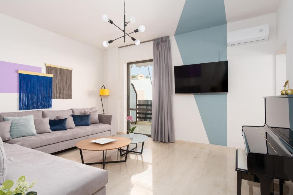 - un salon avec un canapé et une télévision dans l'établissement NIMA 2, modern-style apartment in the heart of Rethimno!, à Réthymnon