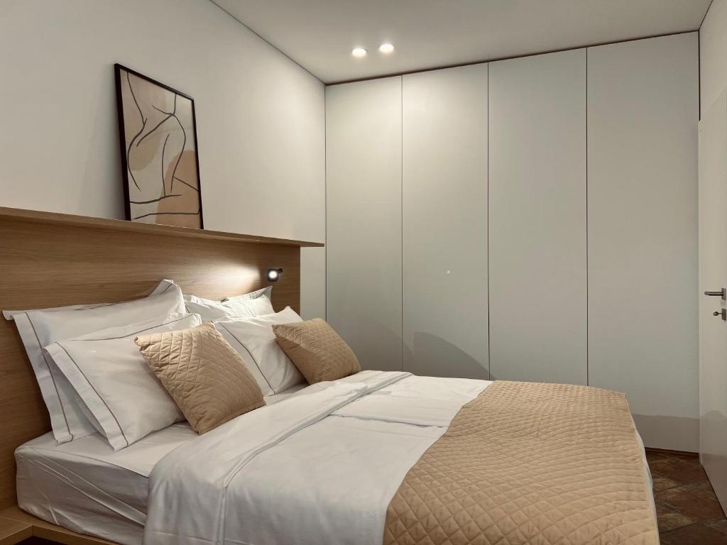 a bedroom with a large bed with white walls at Zaro Apartments in Izola