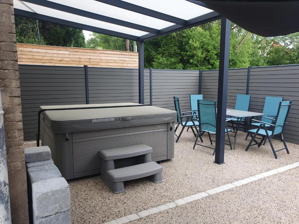 eine Terrasse mit einem Grill, Stühlen und einem Tisch in der Unterkunft Chez Justine in Baccarat