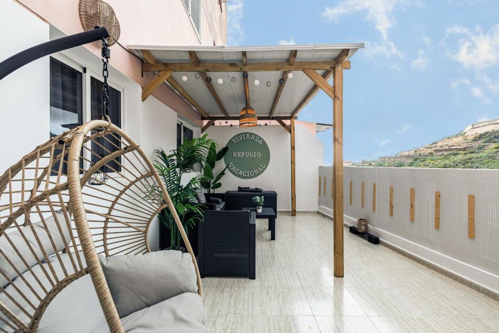 a patio with a hammock on a balcony at Refugio Vacacional in Granadilla de Abona