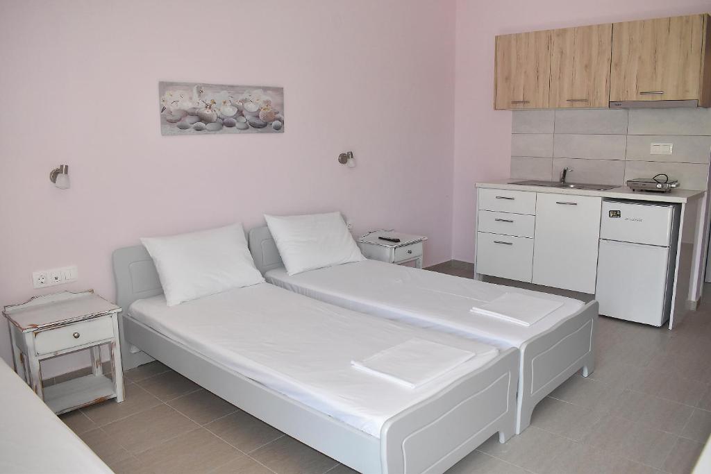 a living room with a white couch in a kitchen at Giorgos-Fenia Apartments in Paralia Katerinis