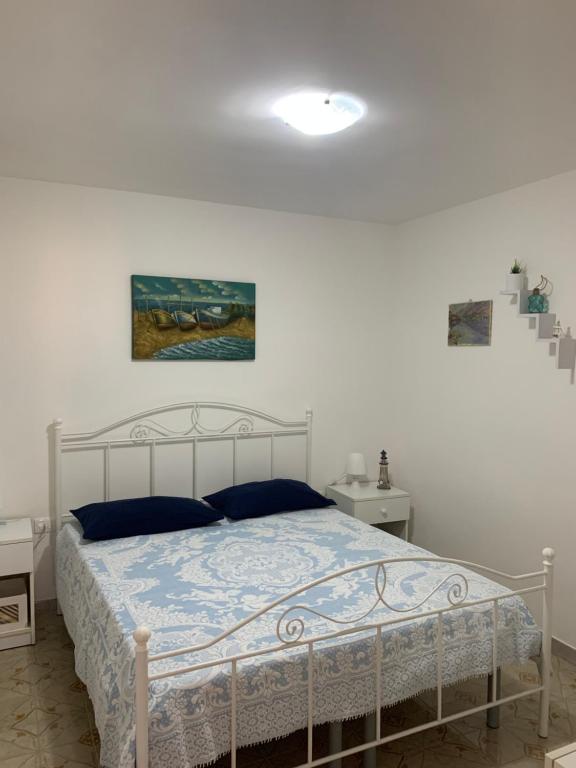 1 dormitorio con cama blanca y edredón azul en VILLA PERLA MARINA en Torre Ovo