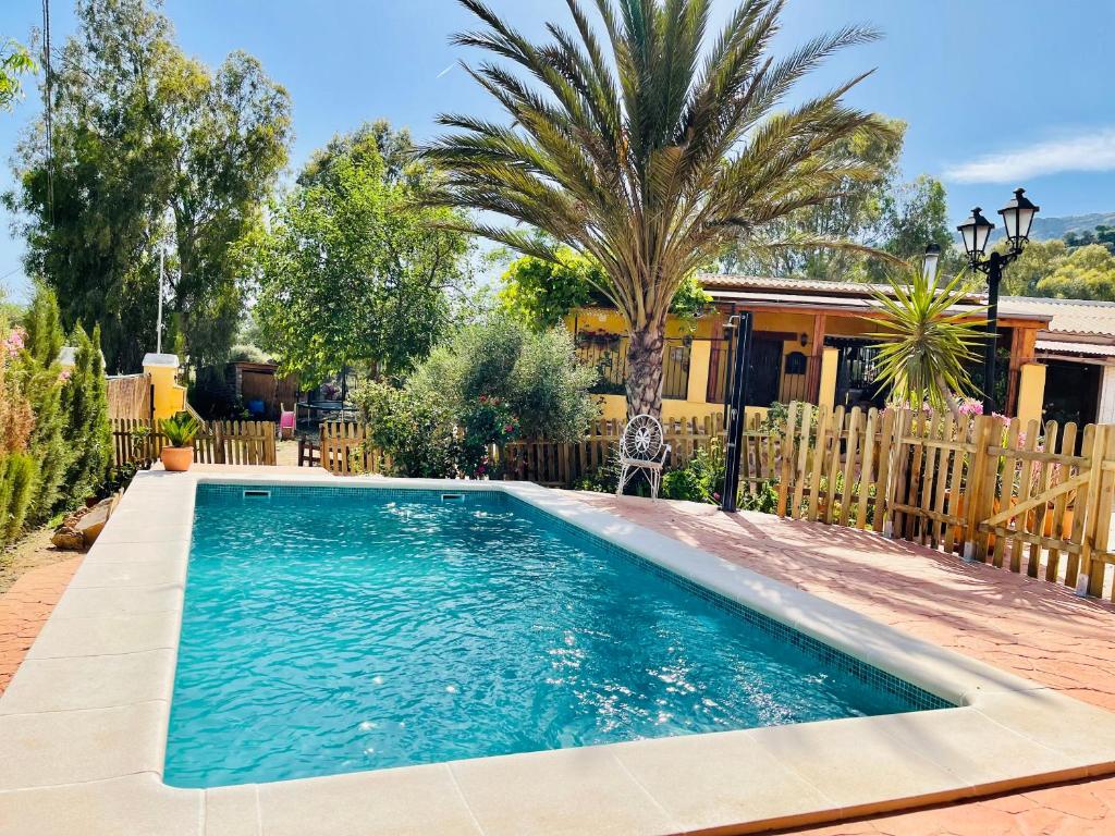 una piscina en un patio junto a una casa en Cortijo el Alcornocal, en Málaga